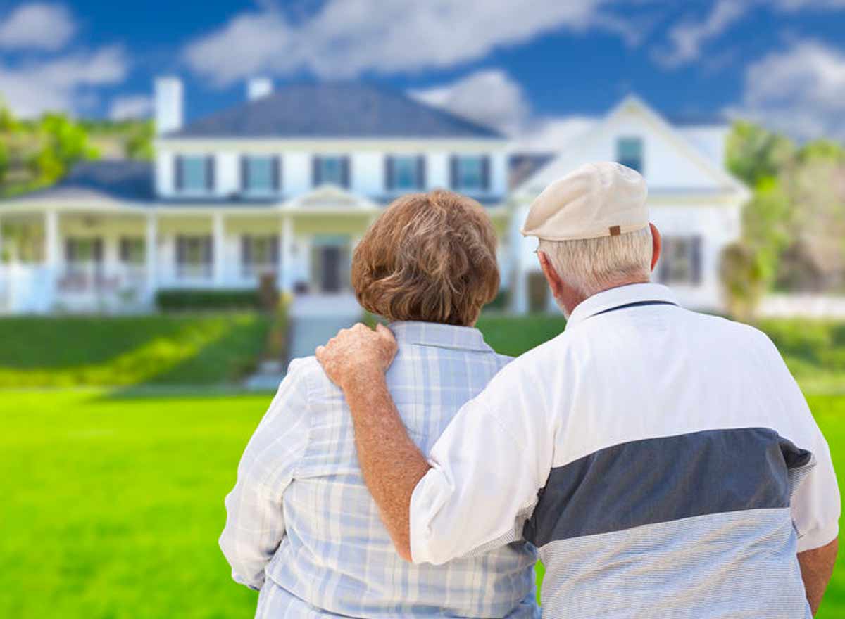 Älteres Ehepaar sitzend vor ihrem Haus