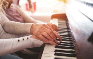 Ältere Senioren mit Enkelin am Klavier