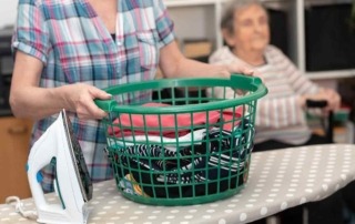 Betreuerin macht Wäsche für Seniorin
