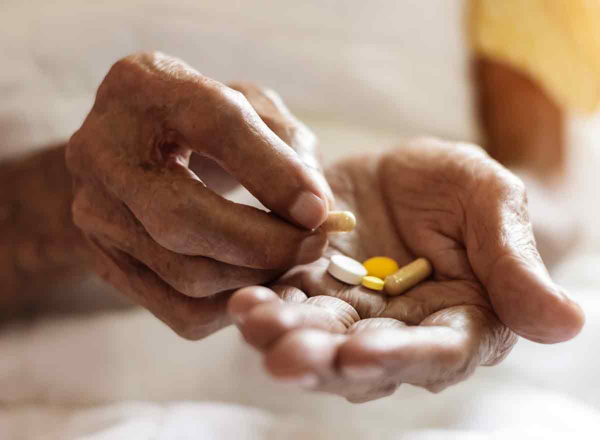 Ältere Person mit Tabletten in der Hand