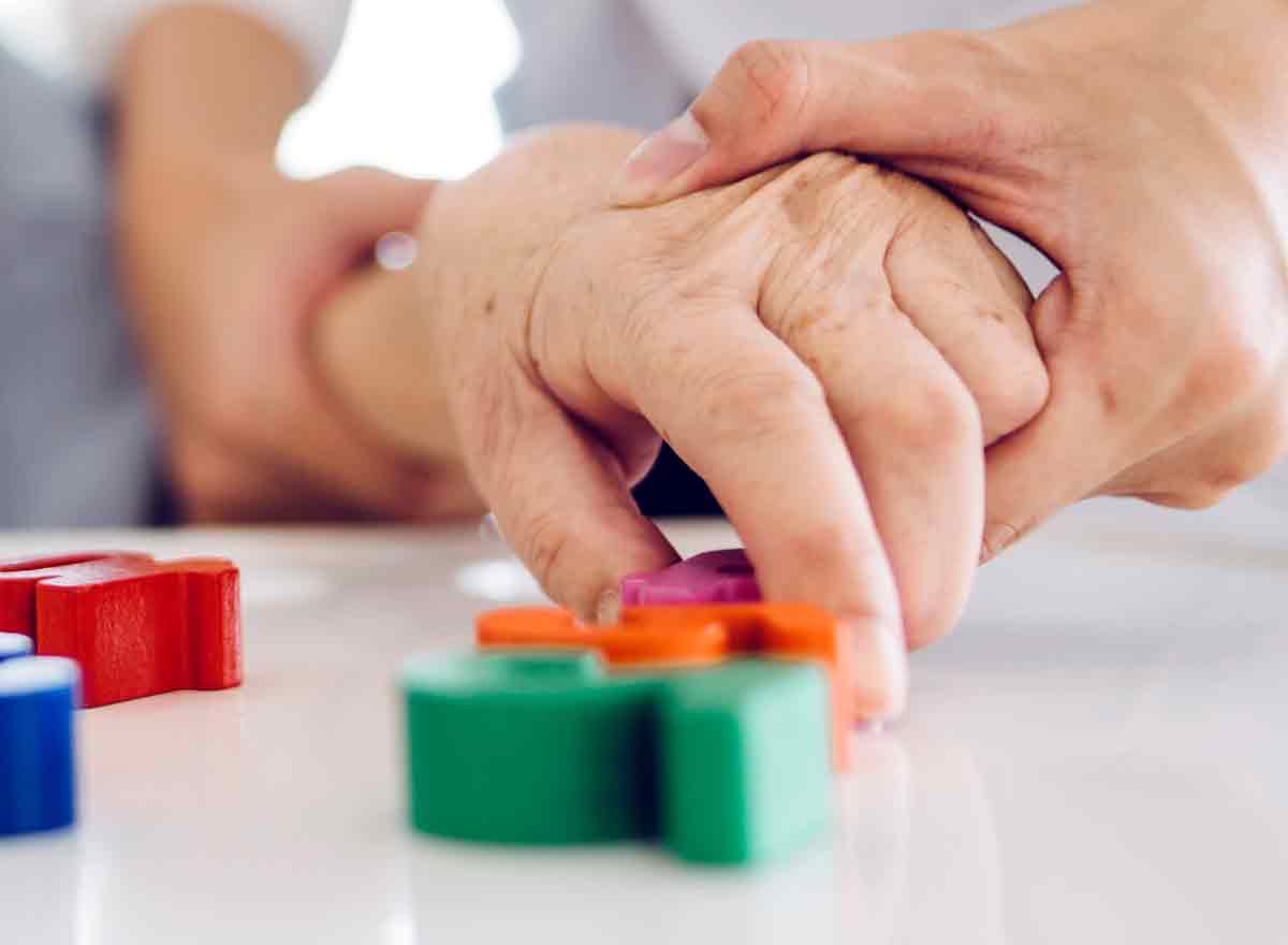 Pflegefachfrau hilft Seniorin beim Spielen